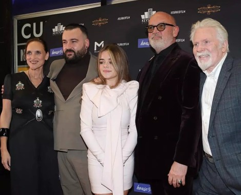 Three men and two women stand in a line for a group photo.